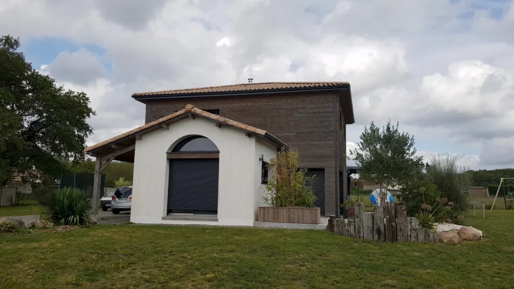 Maison ossature bois avec bardage bois naturel et enduit.