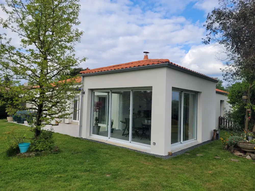 Extension d'une habitation avec des baies vitrées tout le tour pour profiter du jardin toute l'année