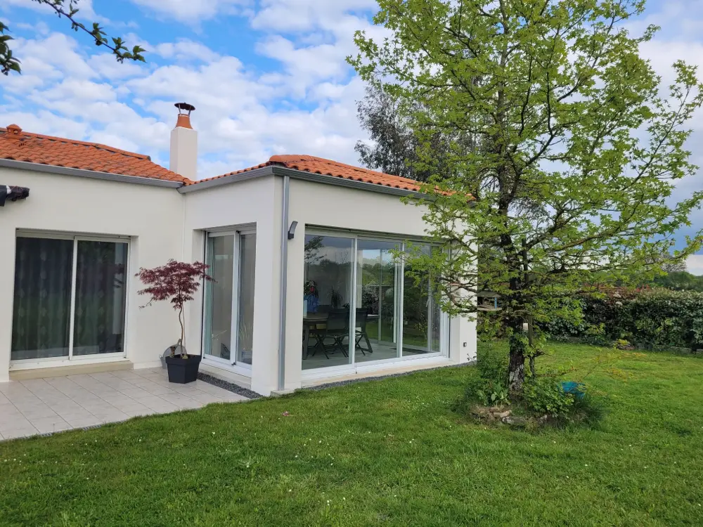 Extension d'une habitation contemporaine en maçonnerie enduite et couverture tuiles